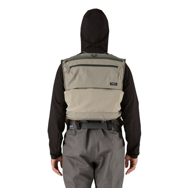 Person wearing fishing waders and the river rock green Patagonia Stealth Pack Fishing Vest with back pocket shown on a white background.