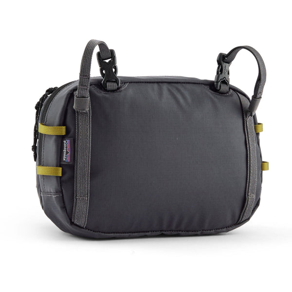 Patagonia Stealth Switch Pack 5L in forge grey with graze green color designed for carrying fishing equipment, on a white background.