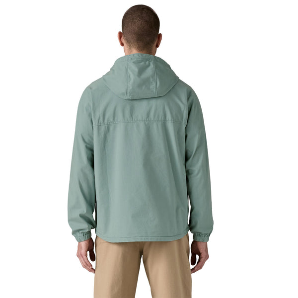 Person wearing khakis and a Patagonia Funhoggers Anorak Pullover in thermal blue featuring a hood and a drawcord on a white background.