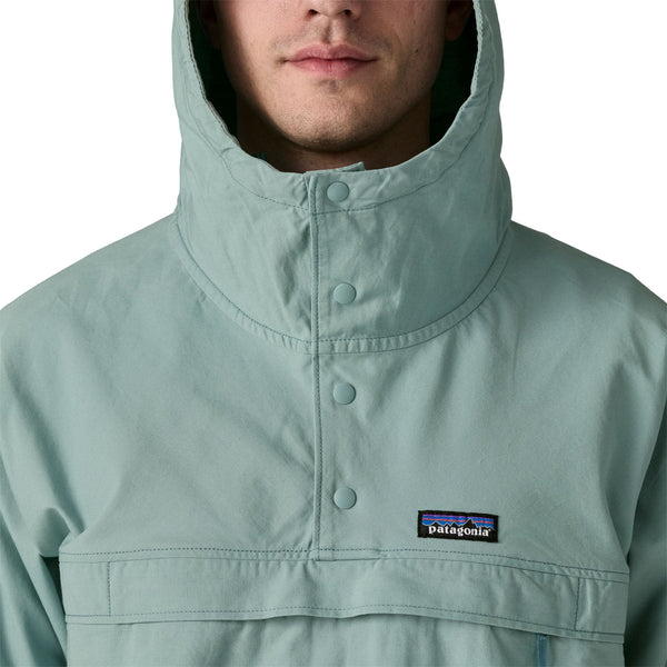 Person wearing khakis and a Patagonia Funhoggers Anorak Pullover in thermal blue featuring a hood on a white background.