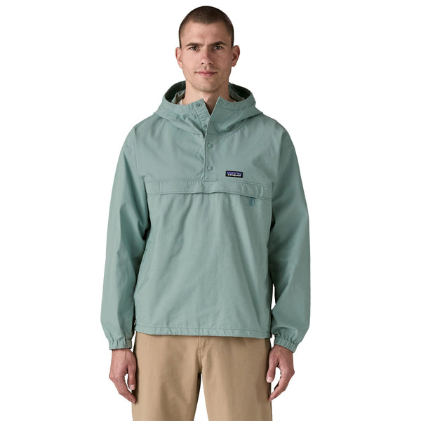 Person wearing khakis and a Patagonia Funhoggers Anorak Pullover in thermal blue featuring a hood and a drawcord on a white background.