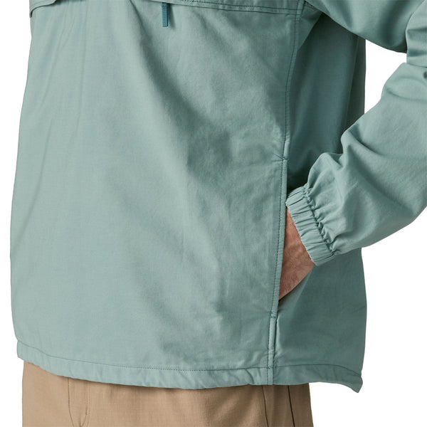 Person wearing khakis and a Patagonia Funhoggers Anorak Pullover in thermal blue featuring a side pocket on a white background.