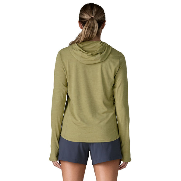 Person wearing a gumtree green x-dye Patagonia Women's Capilene Cool Sun Hoody and black shorts against a white background.
