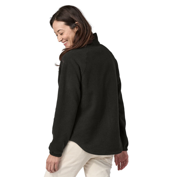 Woman wearing a black fleece Patagonia Classic Microdini Jacket on a white background.