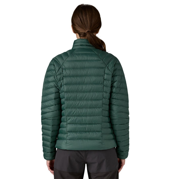 Person wearing a cascade green Patagonia Down Sweater insulated Jacket with black pants on a white background.