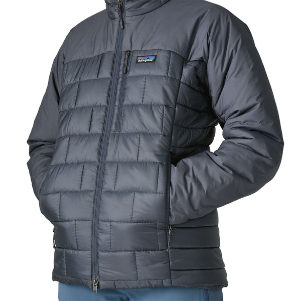 Person wearing the new for 2025 Patagonia Women's Hi-Loft Nano Puff Hoody in smolder blue showing side pocket details on a white background.