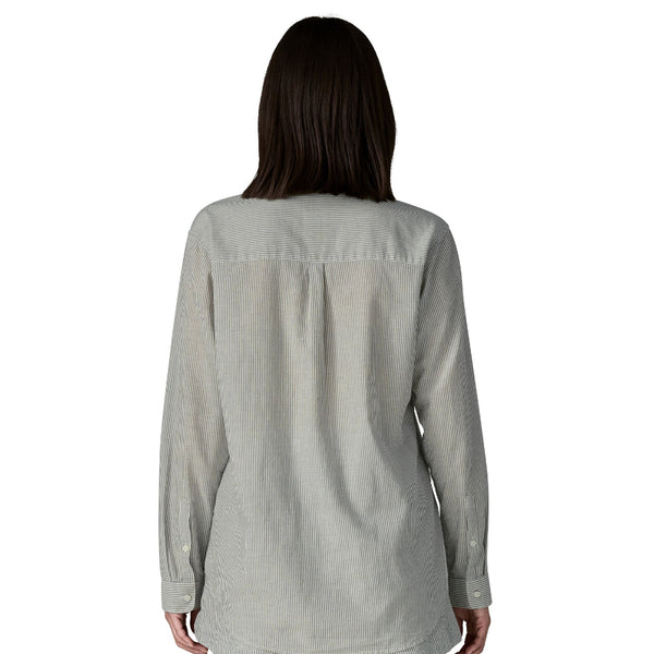 Person wearing a blue and grey stripe long-sleeved Patagonia Women's Lightweight A/C Buttondown Shirt on a white background.