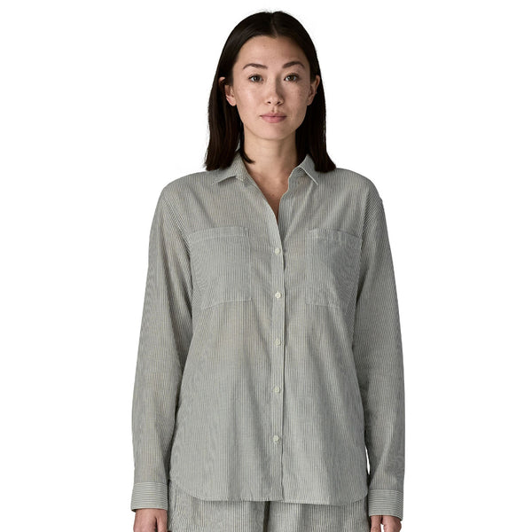 Person wearing a blue and grey stripe long-sleeved Patagonia Women's Lightweight A/C Buttondown Shirt on a white background.