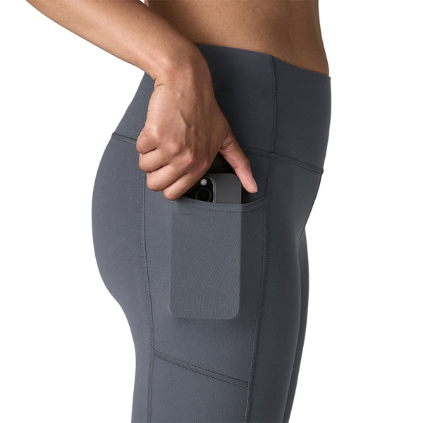 Person wearing smolder blue Patagonia Women's Maipo 7/8 Stash Tights, showing side pocket details, on a white background.