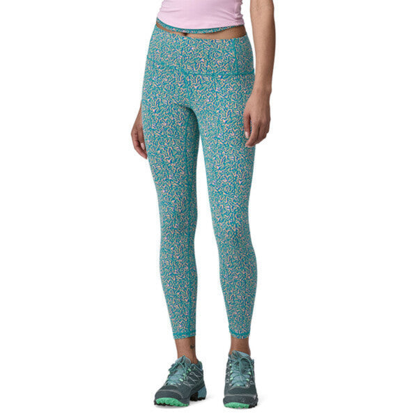 A person wearing a pair of Patagonia Women's Maipo 7/8 Tights in a speckled blue color on a white background.