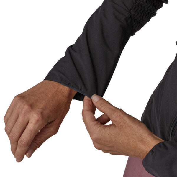 Woman wearing a black Patagonia Women's Nano Air Light Hybrid Jacket showing sleeve details on a white background.