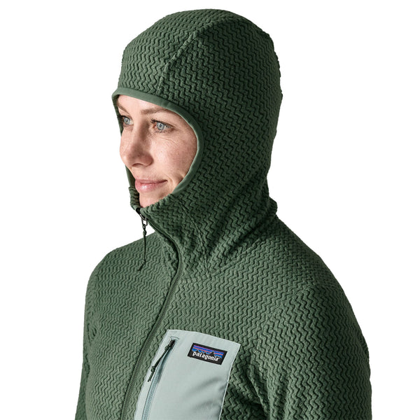 Person wearing the Patagonia Women's R1 Air Fleece Full-Zip Hoody in canopy green color, shown close up and focused on the hood details, against a white background.