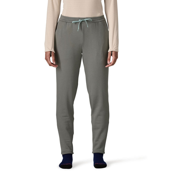 Person wearing a light pink top and noble grey Patagonia Women's R1 Fleece Pants on a white background.