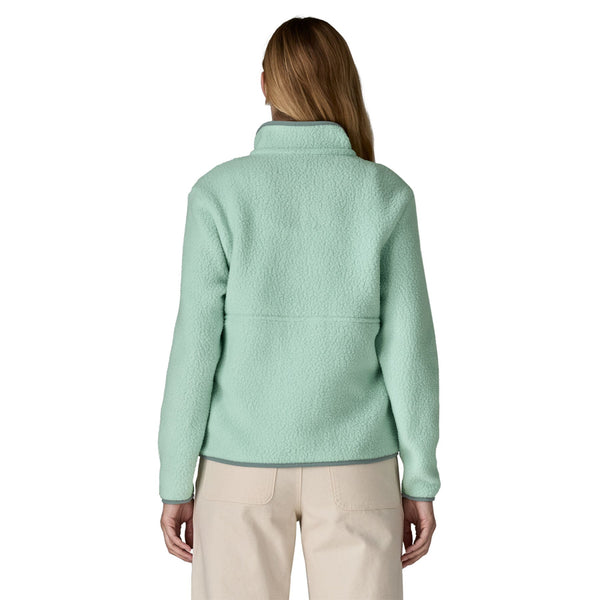 Person wearing a light green Patagonia Women's Retro Pile Marsupial Fleece pullover and tan pants on a white background.