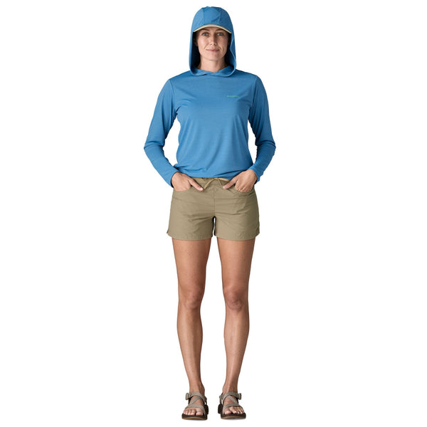 Person wearing a blue top and the Patagonia Women's Sandy Cay Shorts in seabird grey, with drawstring waist and 4 inch inseam, on a white background.