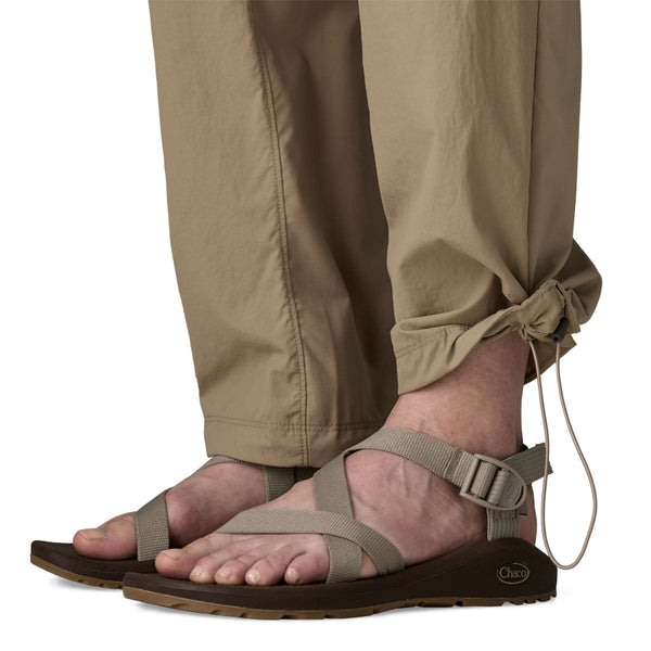 Person wearing seabird grey Patagonia Women's Sandy Cay Wading Pants, showing the cuff toggle details, on a white background.