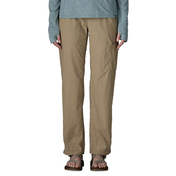 Person wearing seabird grey Patagonia Women's Sandy Cay Wading Pants and sandals on a white background.