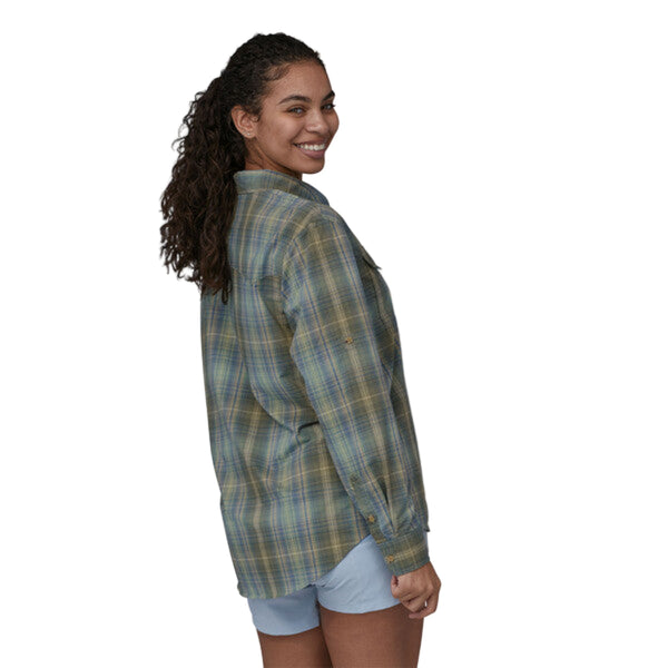 Person wearing a long-sleeved Patagonia women's sun stretch shirt in a plaid pattern with chest pockets, on a white background.
