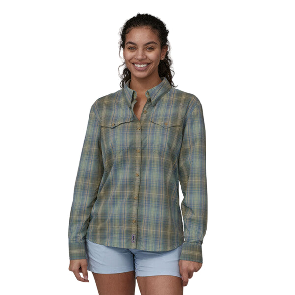 Person wearing a long-sleeved Patagonia women's sun stretch shirt in a plaid pattern with chest pockets, on a white background.