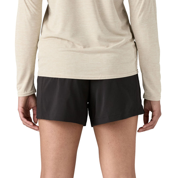Person wearing a beige long-sleeve shirt and black Patagonia Women's Terrebonne Shorts on a white background.