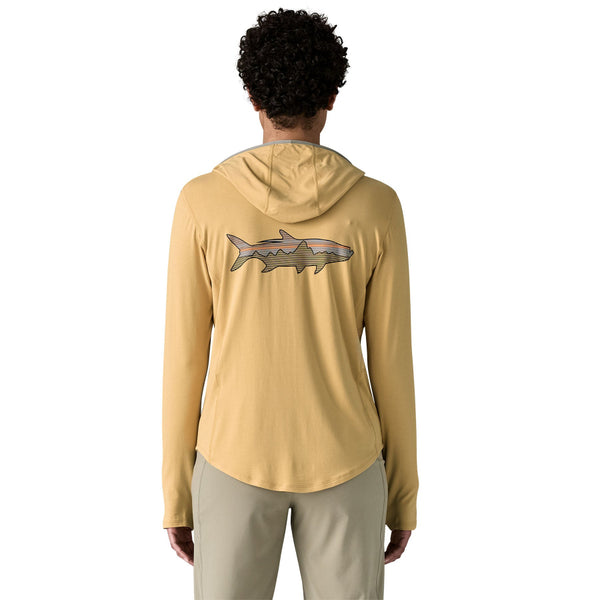 Person wearing a Patagonia Women's Tropic Comfort Natural Graphic Hoody in beeswax tan with the Patagonia fitz roy tarpon logo on the back, featuring a hood, long sleeves, and thumb loops over a white background.