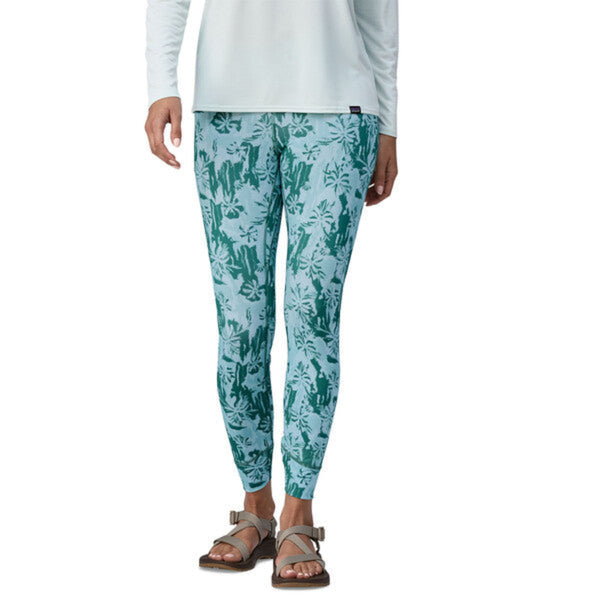 Person wearing Patagonia Women's Topic Comfort UPF Sun Tights in green cliffs and waves pattern on a white background.