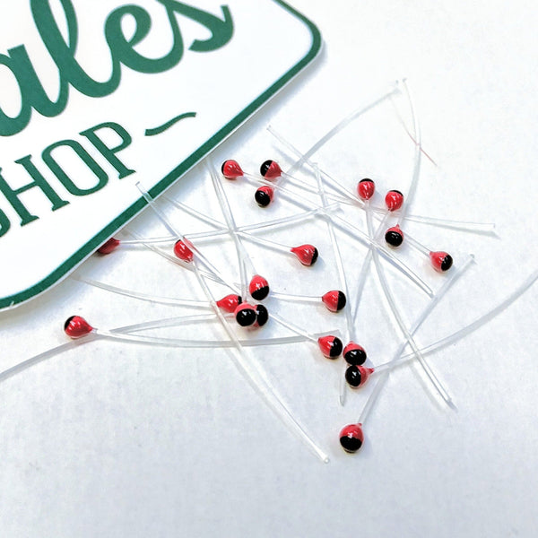A group of red and black mono stalk eyes for fly tying on a white background.