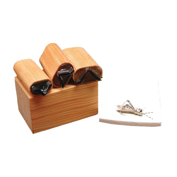 A selection of different sized River Road Creations  Hopper Leg Foam Cutters showing the cutting pad, and an example completed foam hopper fly, against a white background.
