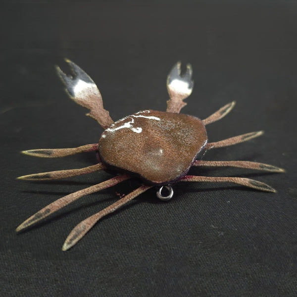 Artificial crab fly tied with the Semperfli ABC Crab Legs and Claws Skeleton on a dark background..