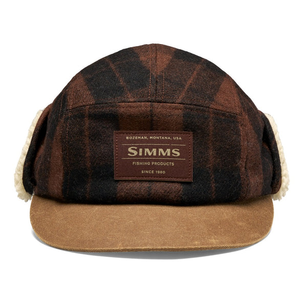 A Simms Coldweather Cap with a brown hickory duke plaid pattern, light brown visor, and cream sherpa ear flaps, shown against a white background.