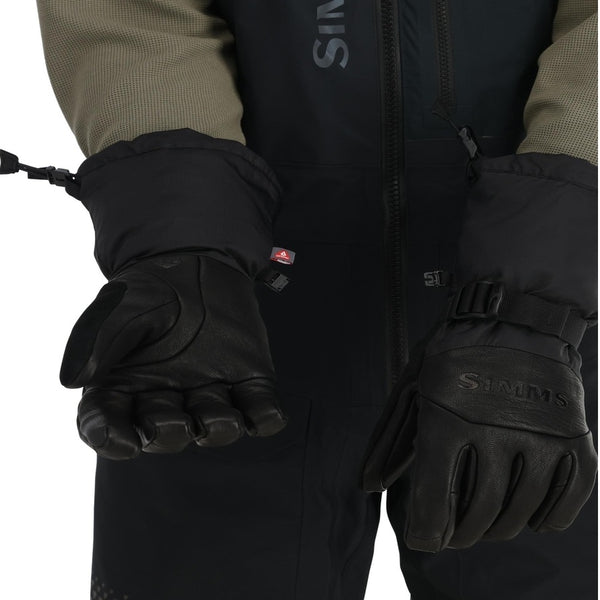 Person in coveralls wearing a pair of black Simms Guide Insulated gloves on a white background
