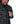 Person wearing a Shroud Black camouflage Simms Men's Rogue Fleece zip front hoody showing a close up of front zipper pocket details on a white background.