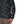 Person wearing a Shroud Black camouflage Simms Men's Rogue Fleece zip front hoody showing a close up of side pocket details on a white background.