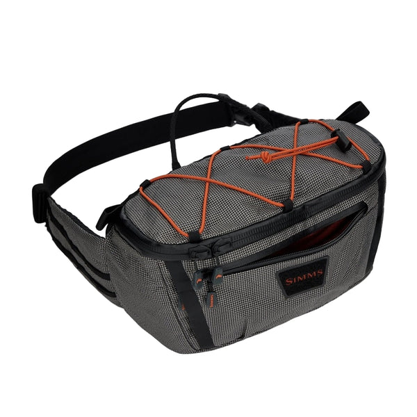 Black and gray Simms Scout Hip Pack bag with orange accents shown from the top on a white background.