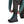 A person kneeling forward wearing Simms Women's Tributary Stockingfoot Waders zoomed in on the leg and gravel guard details on a white background.