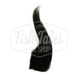 A patch of black dyed Troutline Premium Long Goat Fur for fly tying showing the full length of hair fibers, on a white background with the Fish Tales logo watermark.
