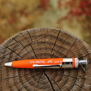 A Ty-Rite EZ Ty Hook Holder, model Junior, placed on a wooden surface with a blurred background.