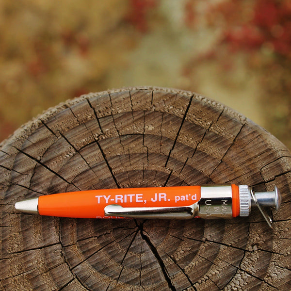 A Ty-Rite EZ Ty Hook Holder, model Junior, placed on a wooden surface with a blurred background.