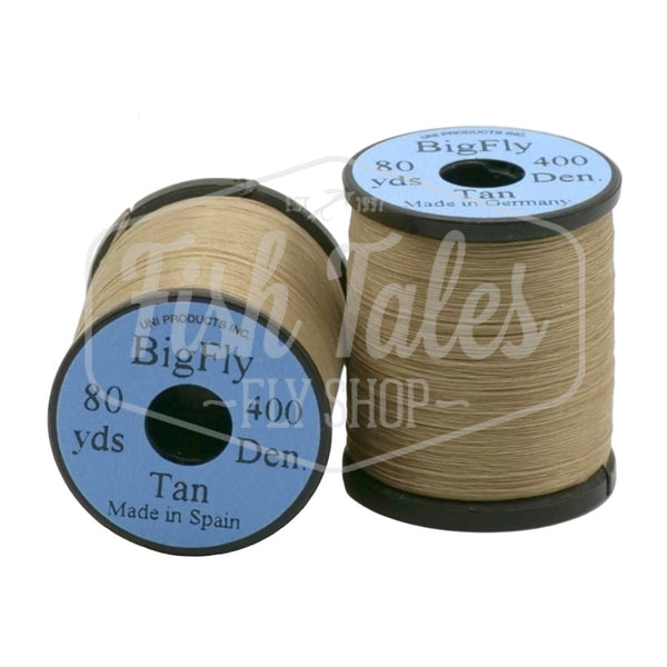 Two spools of tan UNI Big Fly fly tying thread on a white background.