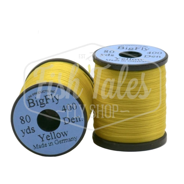 Two spools of yellow UNI Big Fly fly tying thread on a white background.