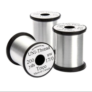 A group of 3 spools of white UNI Trico 17/0 fly tying thread n a white background/
