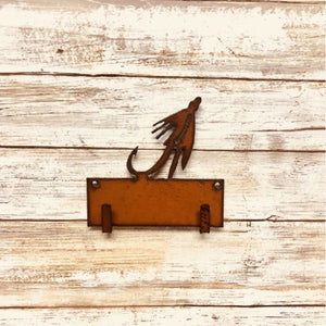 Metallic brown wall mounted Universal Ironworks Fishing Fly Key Holder, on a light wooden background.