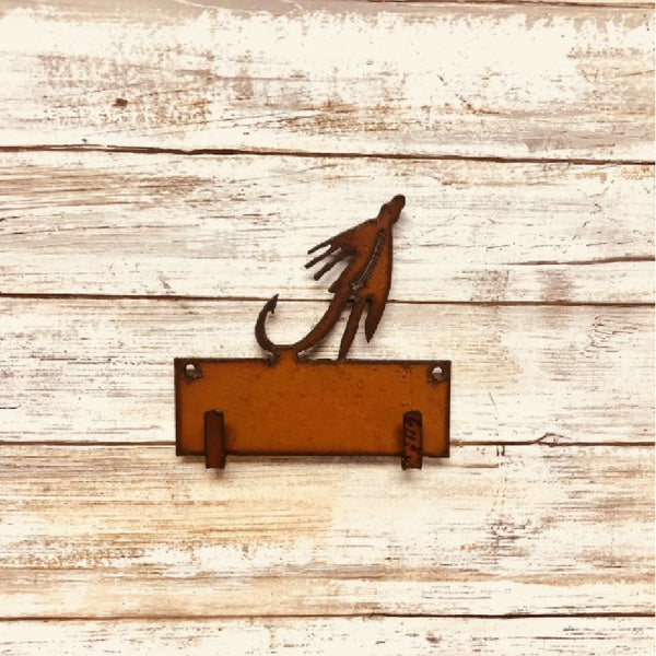 Metallic brown wall mounted Universal Ironworks Fishing Fly Key Holder, on a light wooden background.