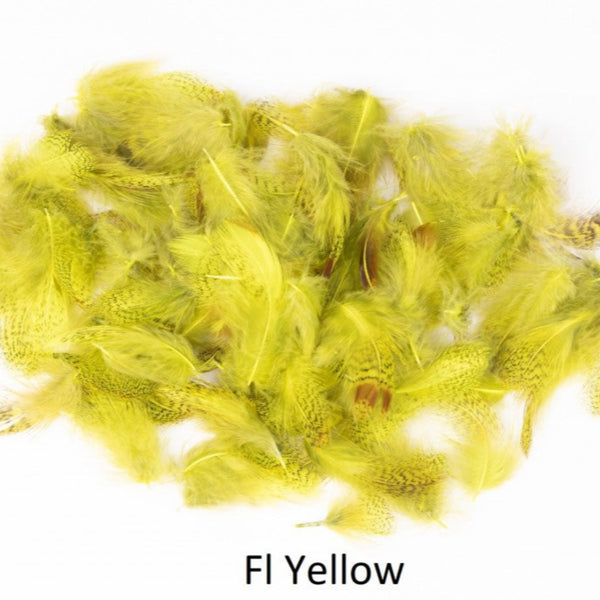 A pile of dyed fluorescent yellow English partridge neck feathers on a white background.