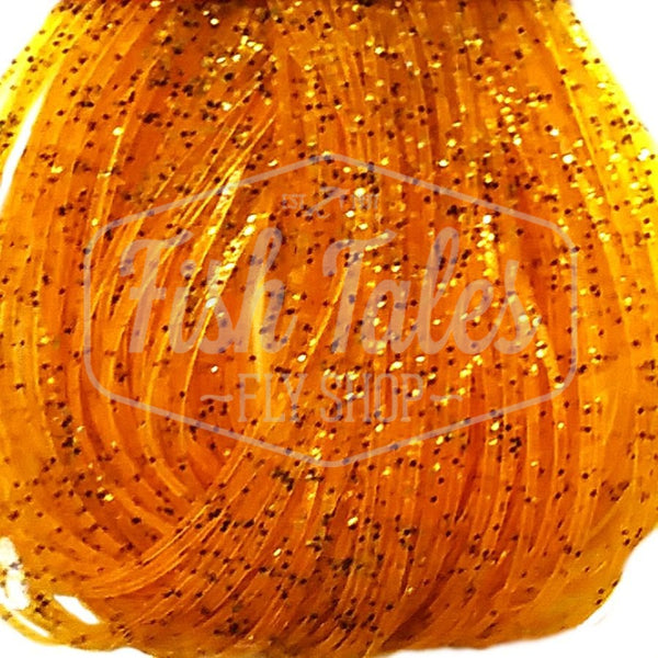 Amber with gold and black flake Speckled Flake Wapsi Sili Legs for fly tying shown close up on a white background.