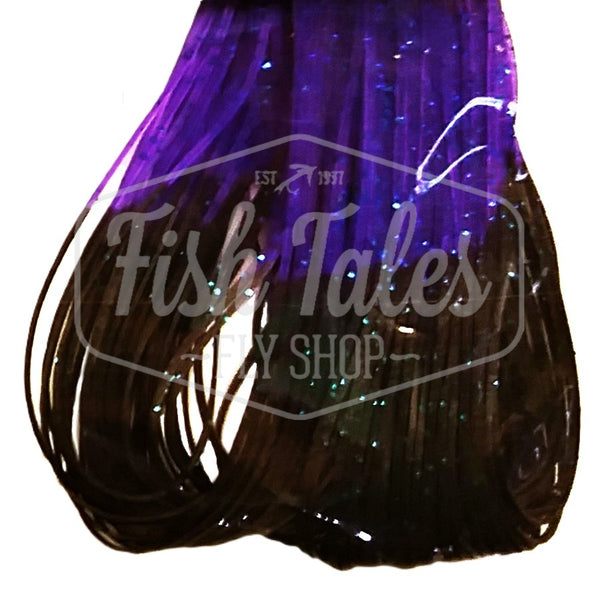 Black with purple Fire Tip Wapsi Sili Legs for fly tying shown close up on a white background.