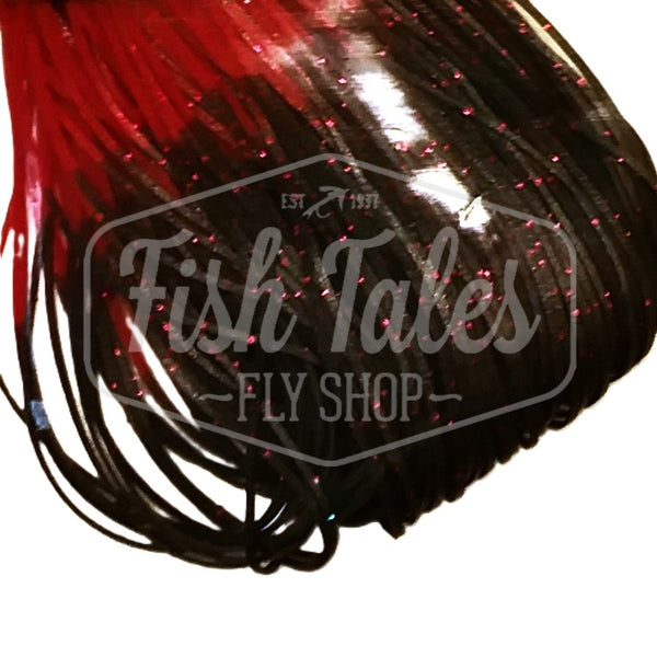 Black with red Fire Tip Wapsi Sili Legs for fly tying shown close up on a white background.