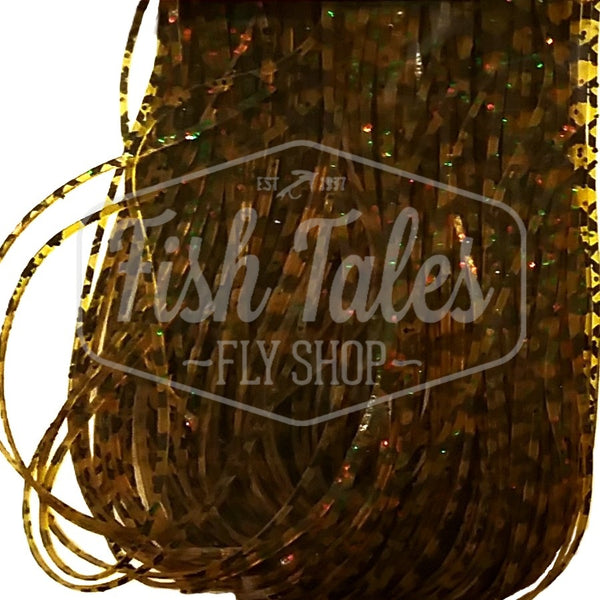 Pumpkin with orange, green and black Scale Barred Wapsi Sili Legs for fly tying shown close up on a white background.
