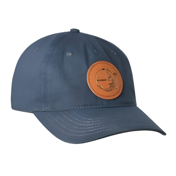 front view of a single sage chasing trout full cloth ball cap in navy showing round leather patch with trout and sage logo on a white background