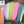 Assorted colors Just Add H2O Deadly Dazzle fly tying material on a wood grain background.